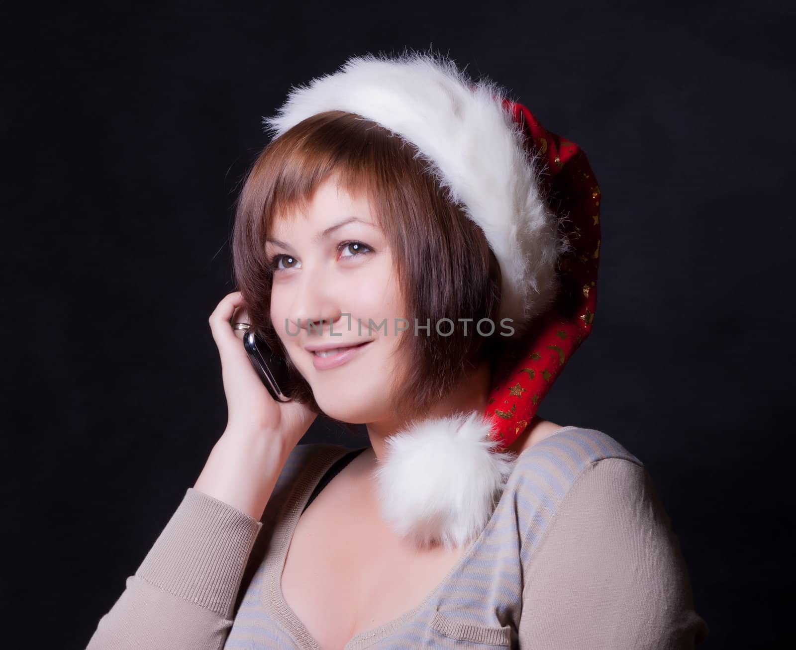 young woman in christmas cap, black background