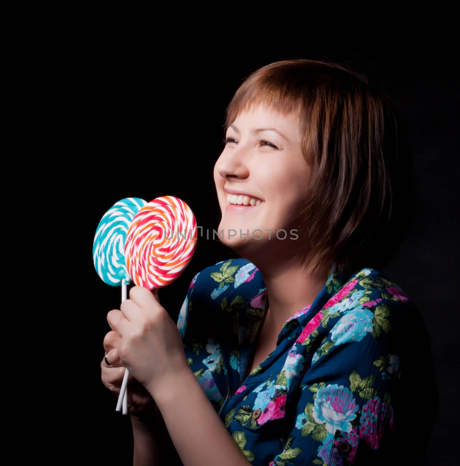 young woman with lollipop, black background