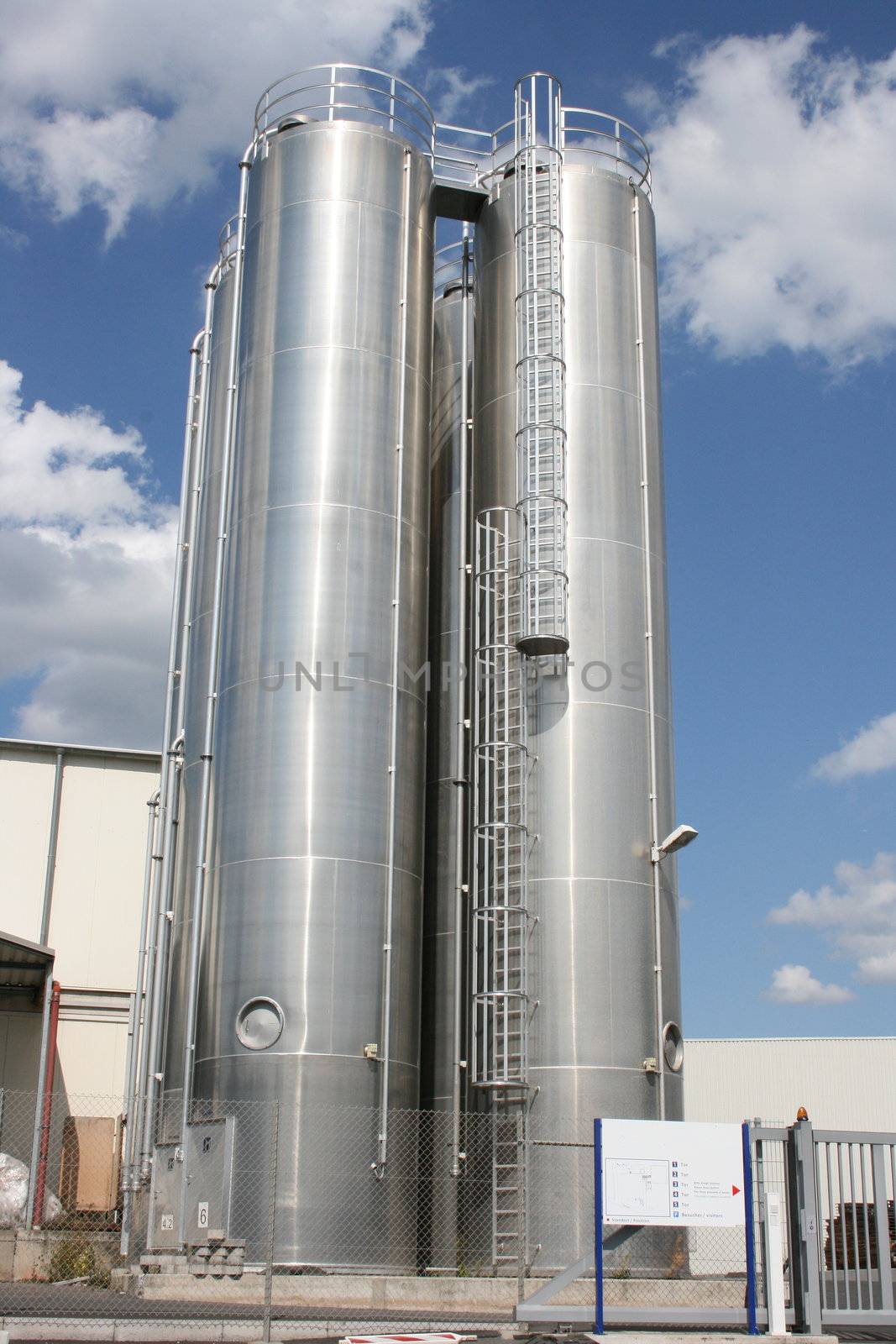 zwei runde Industrietanks mit blauem Himmel als Hintergrund	
two round industrial tanks with blue sky as background