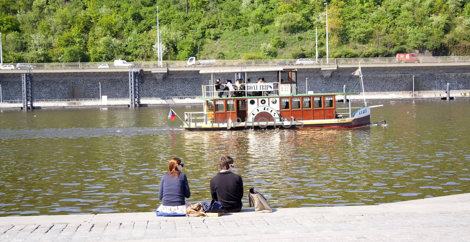 people sitting on the creek. rest. Prague, Czech Republic.