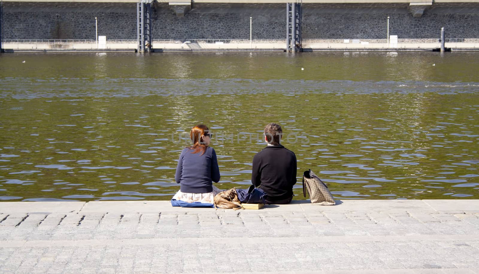people sitting on the creek. rest. Prague, Czech Republic.