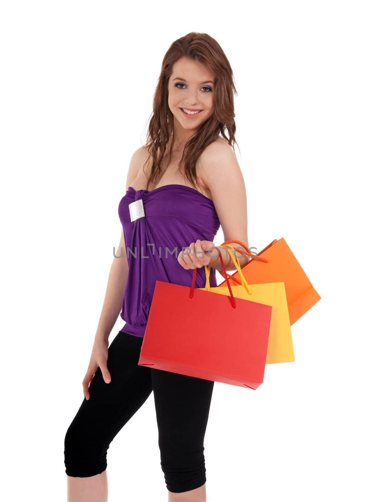 Smiling young girl holding colorful shopping bags, isolated on white.