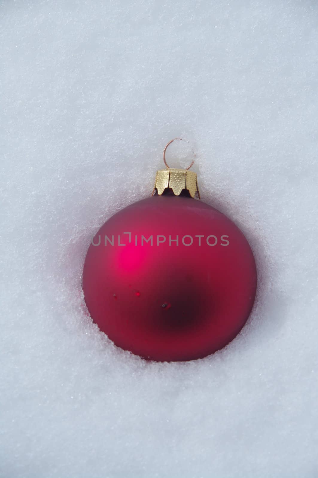 a red bauble in snowy lwinter andscape