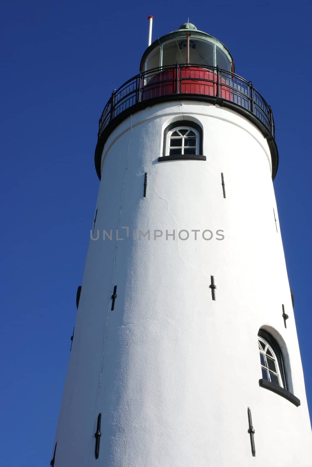 Wonderful white lighthouse taken against a clear blue sky.