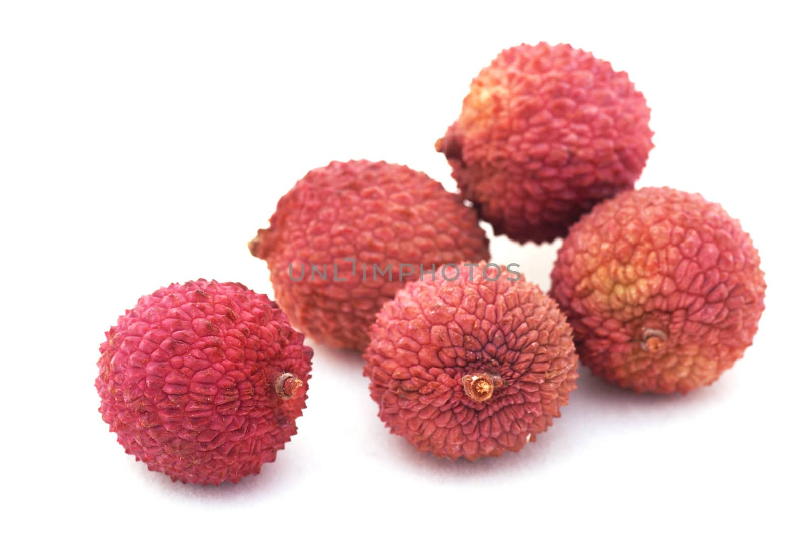 Five colorful lychees isolated on a white background.