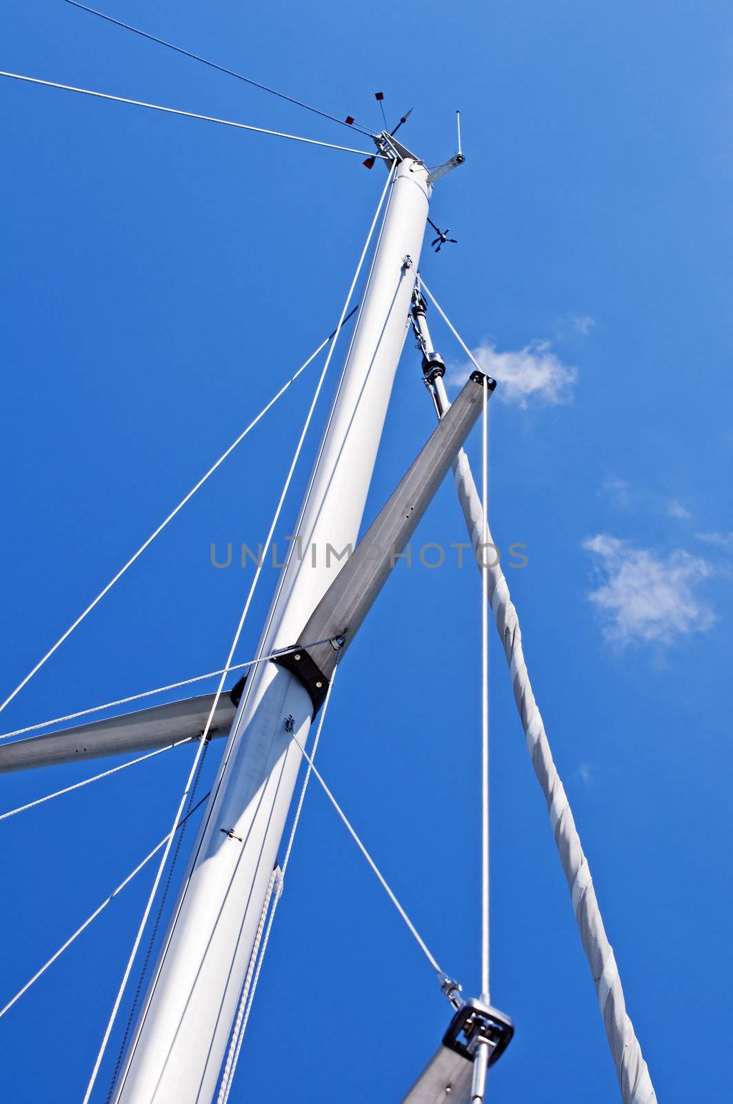 Mast of a sailboat against a blue sky