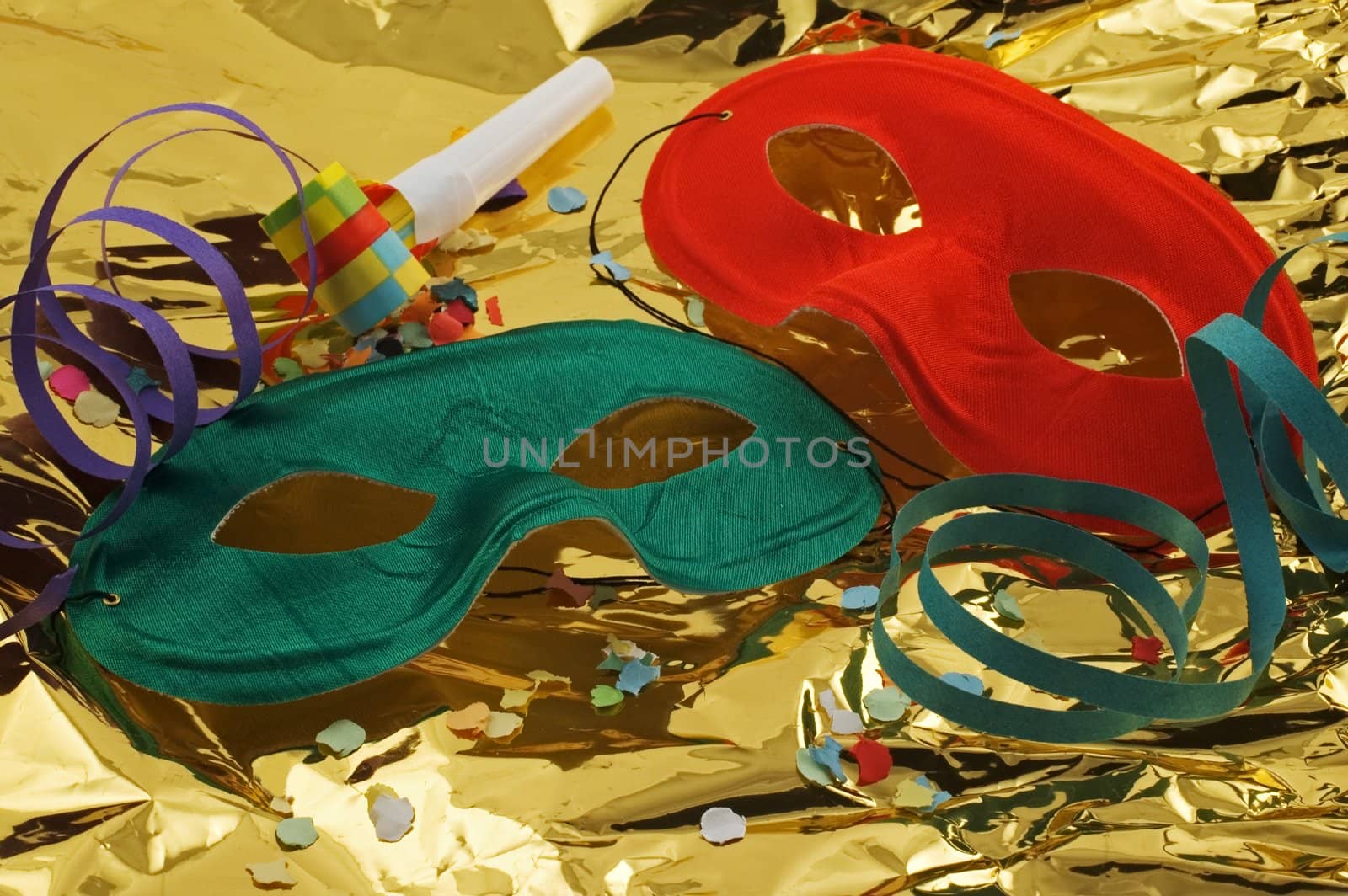 Two masks on golden background with confetti, streamers and noisemaker