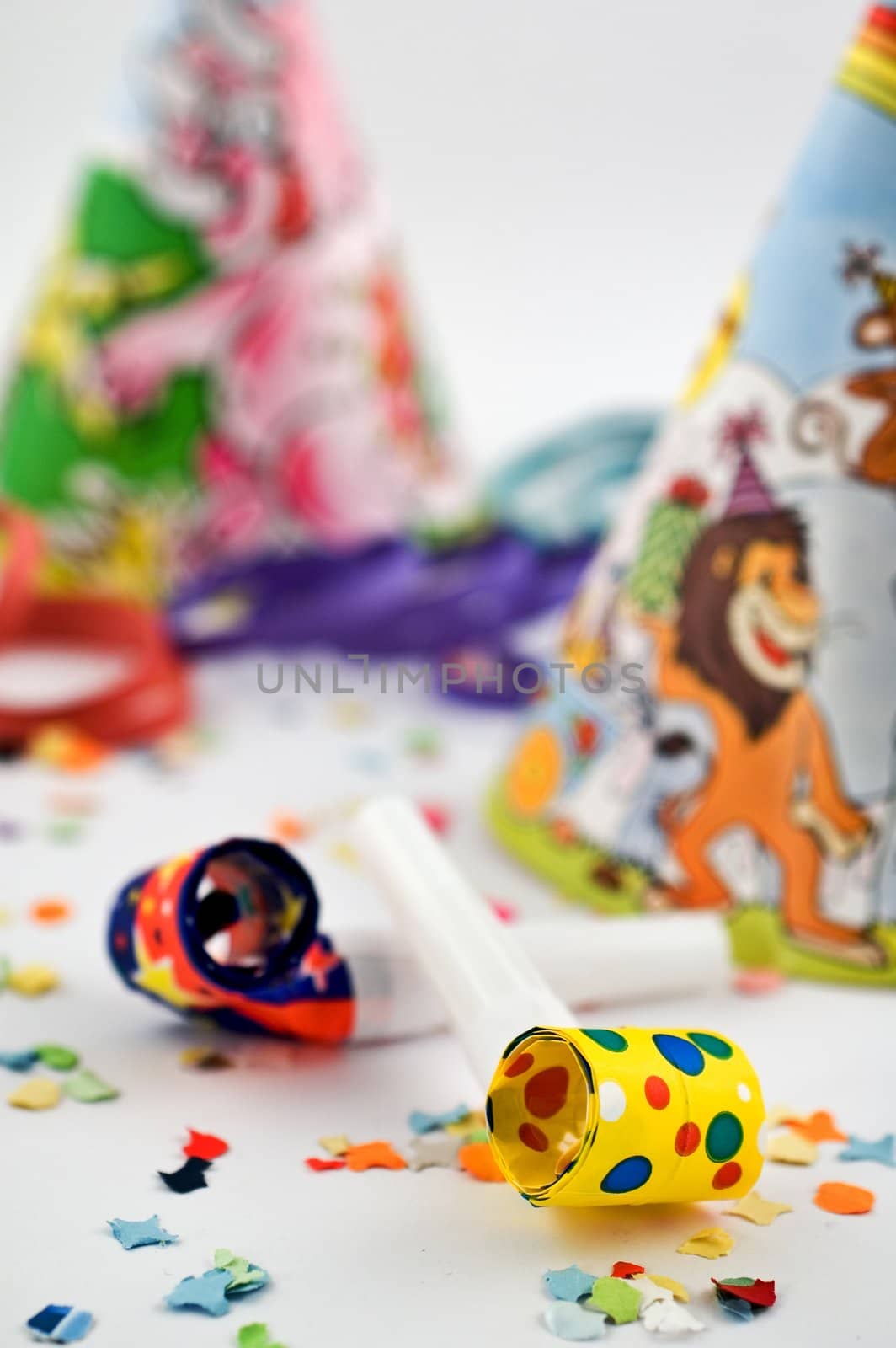 Party blowers with party hats, streamers and confetti with selective focus