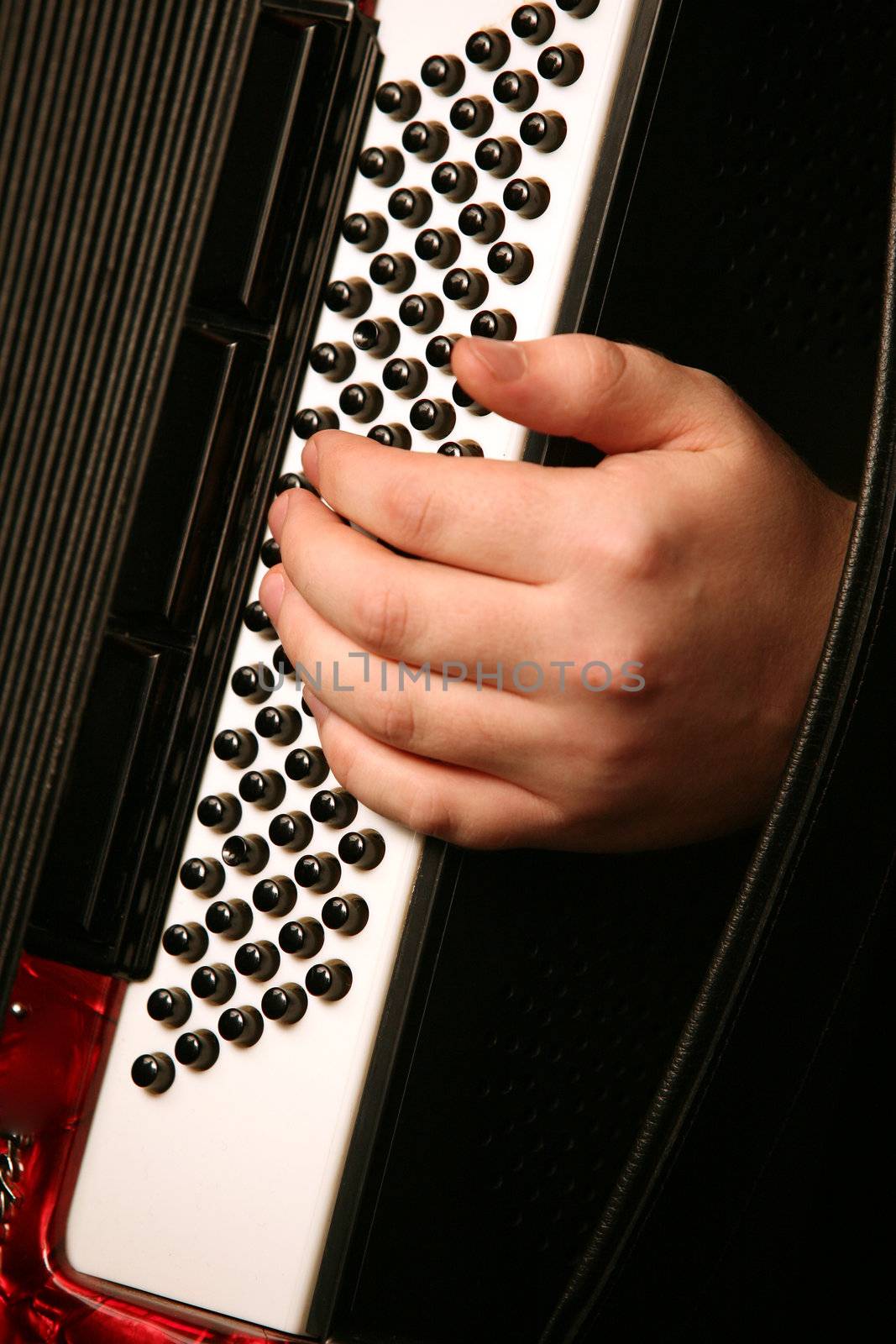 Hand of the musician with the instrument on a black background