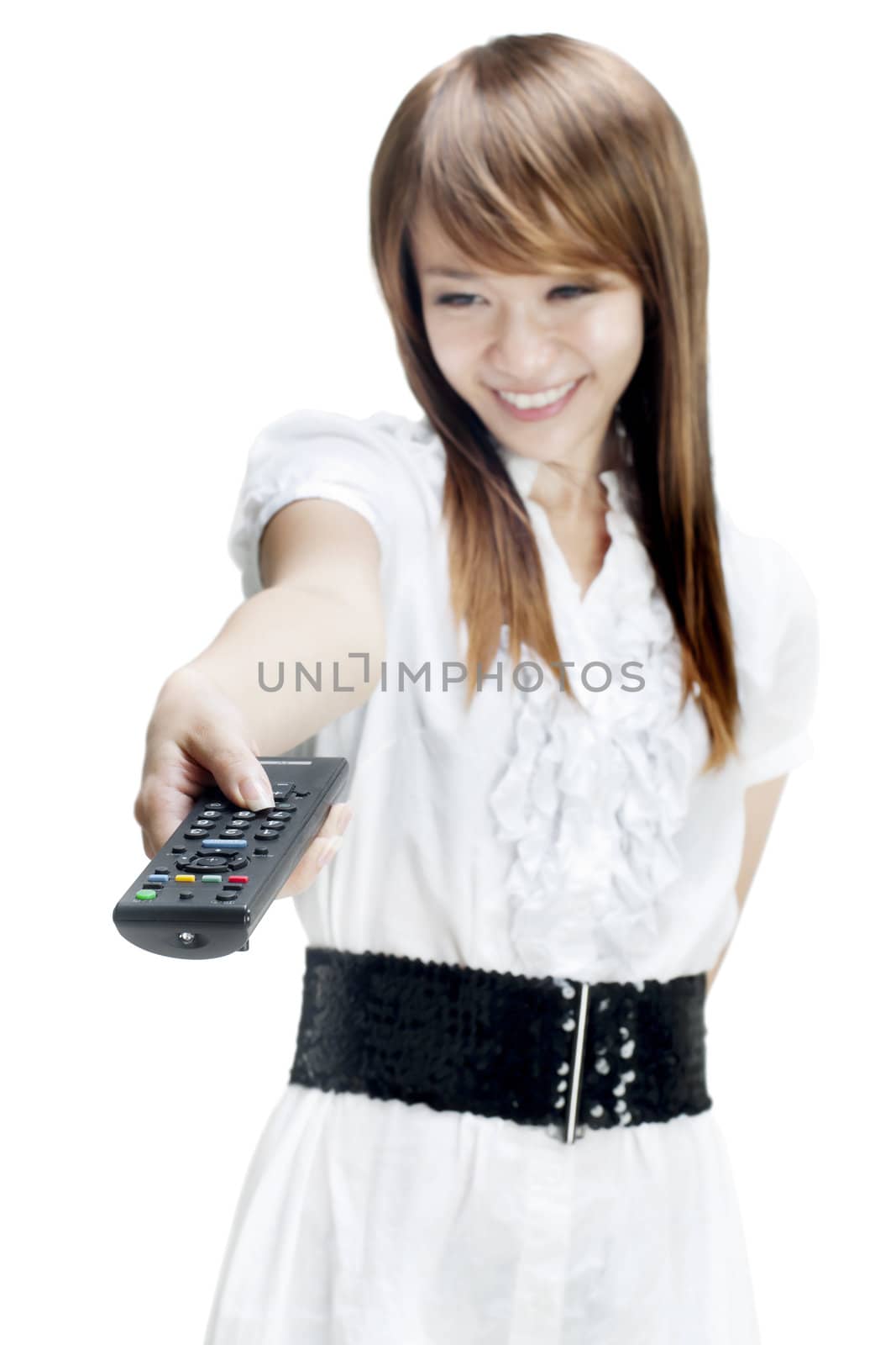 Young woman holds out a remote control to change television stations.