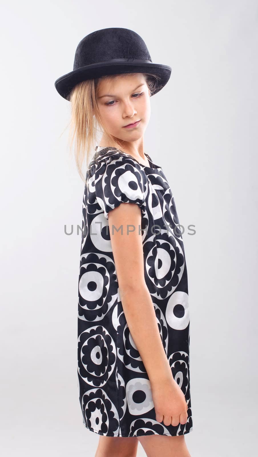 Pretty girl in a beautiful dress and a hat in the studio