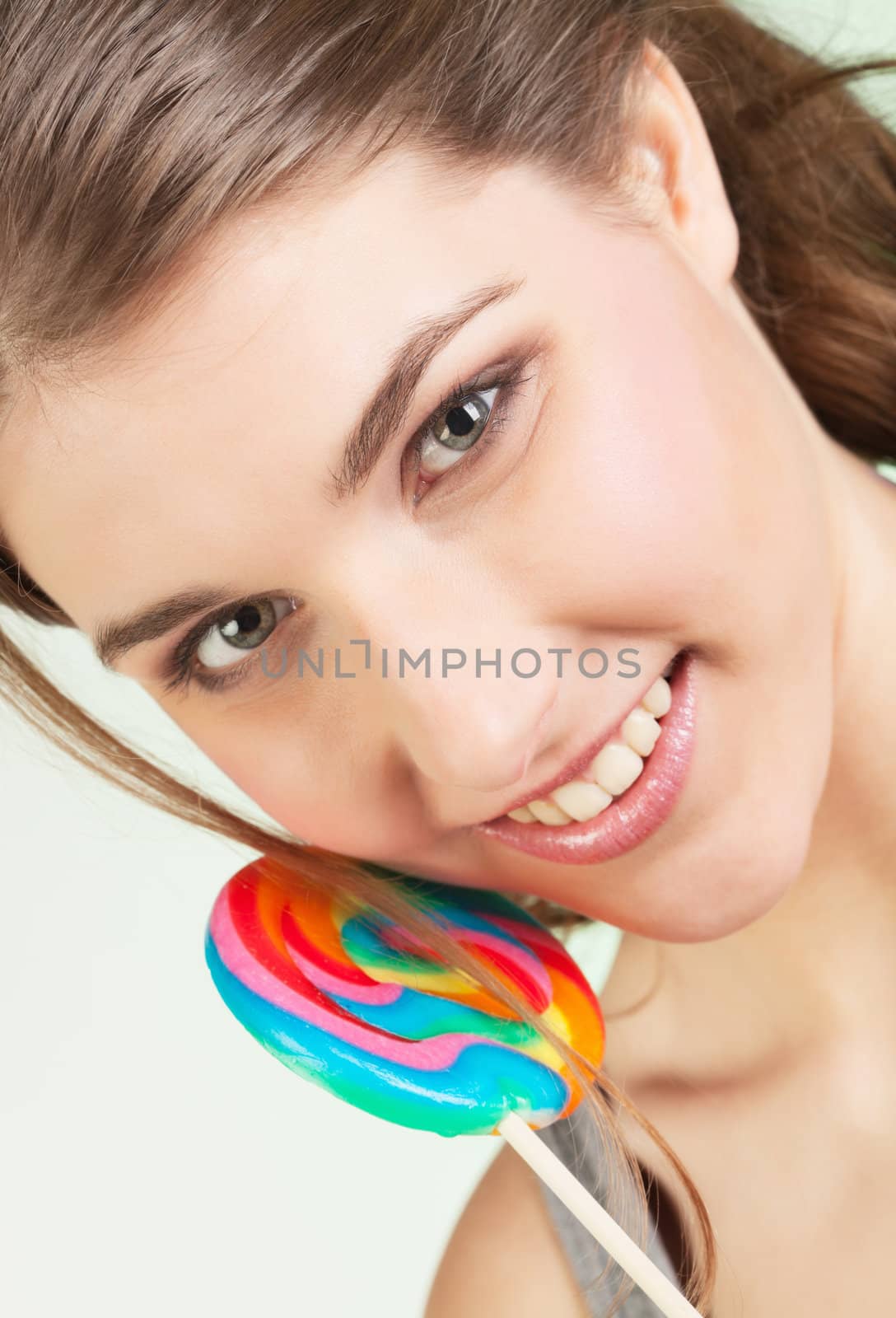 Portrait of smiling teenager girl holding colorful lollipop