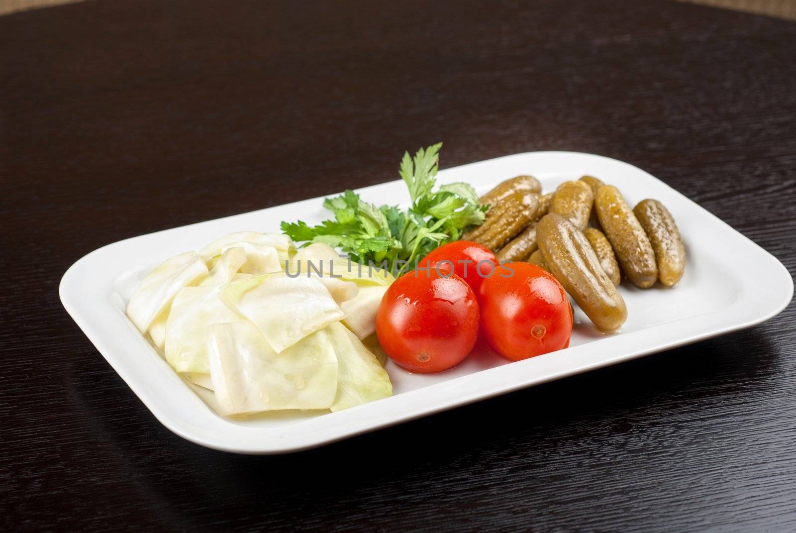 pickled vegetables of tomato, cucumber, cabbage at white plate