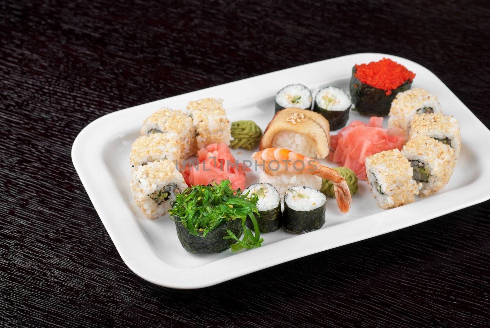 japanese sushi set and sushi with green seaweed closeup in the foreground