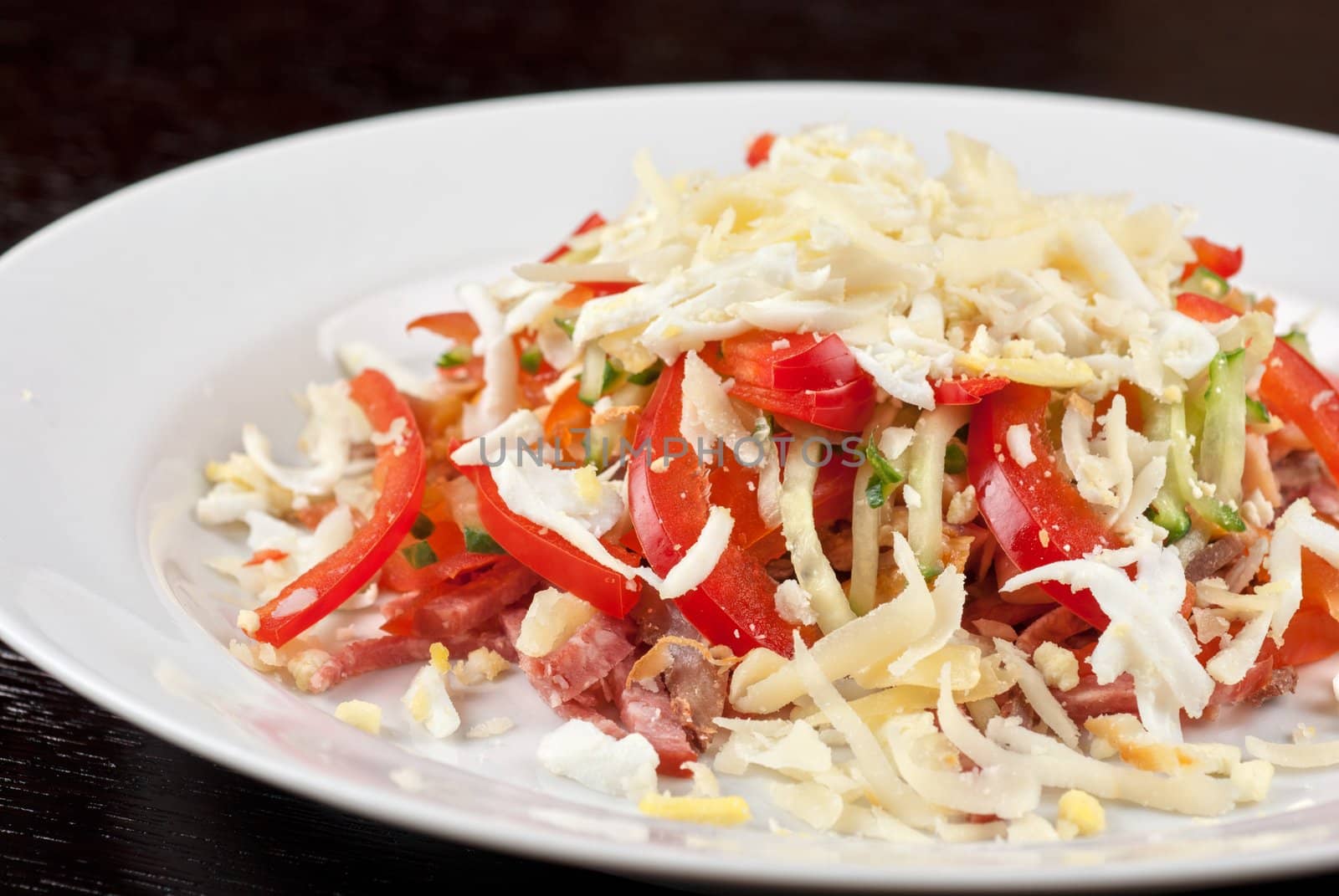 Salad from beef tongue, cervelat, chicken meat, fresh tomatoes, cucumbers, pepper, eggs, cheese and mayonnaise