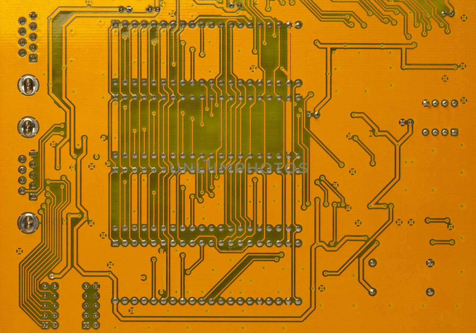 Back of computer circuit board in orange and green