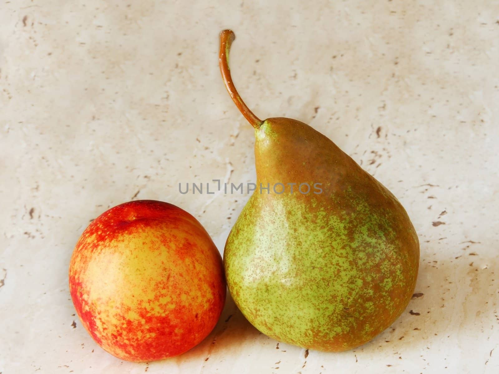two ripe fruits, peach and pear, on the table