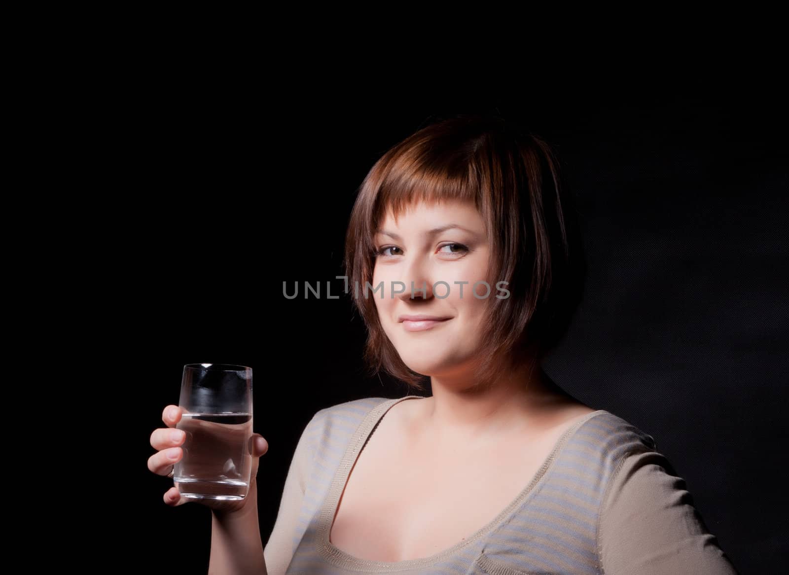 young woman with glass water, black background