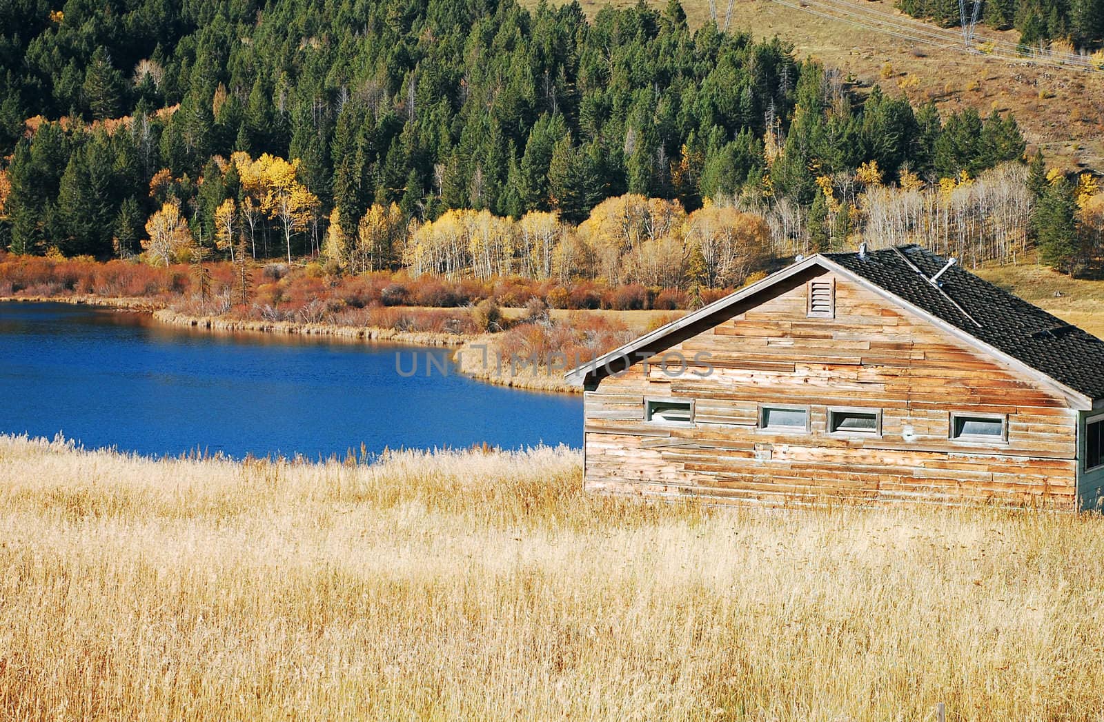 Old wooden cabin next to blue lake