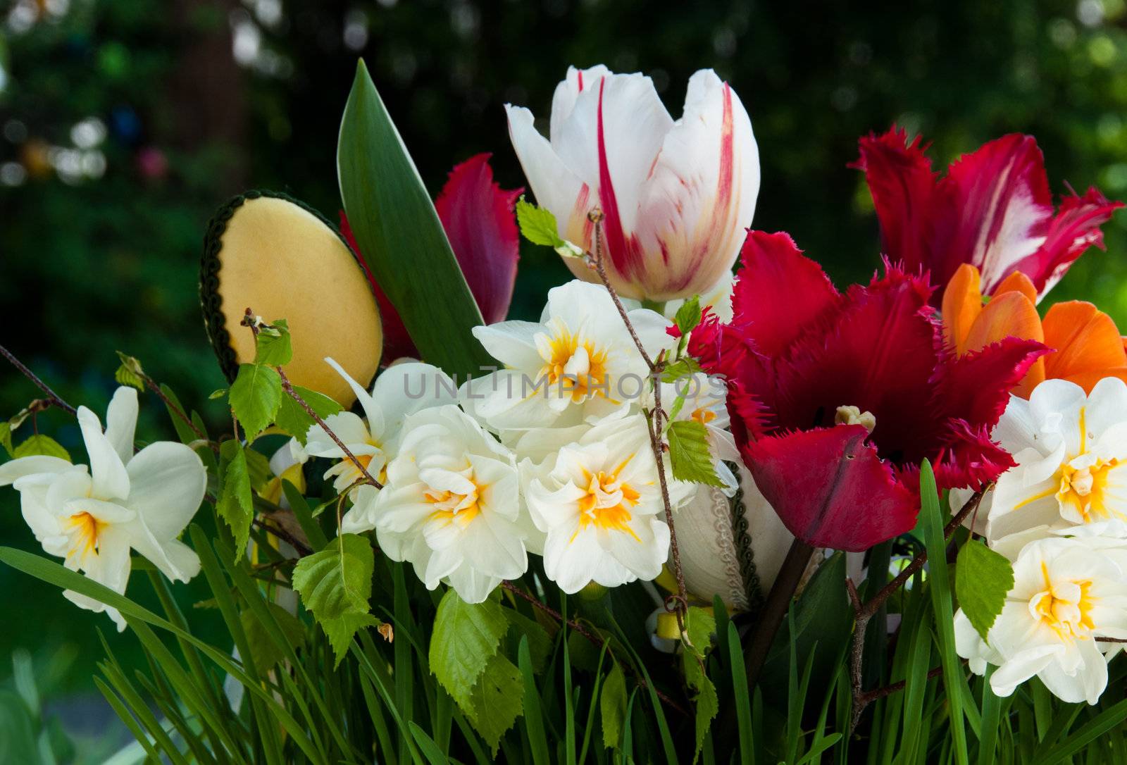 Bouquet of spring flowers (daffodils and tulips) with Easter eggs