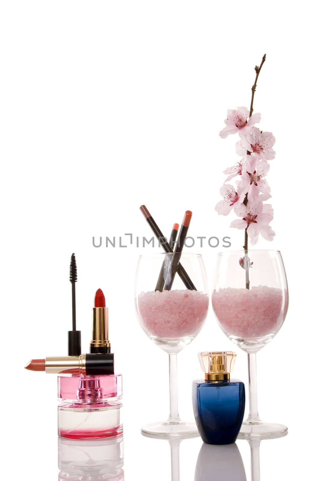 perfume bottles, lipsticks, cosmetics and cherry flower on white background