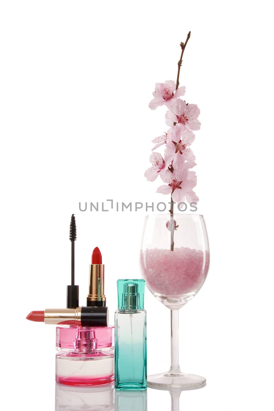 perfume bottles, lipsticks, cosmetics and cherry flower on white background