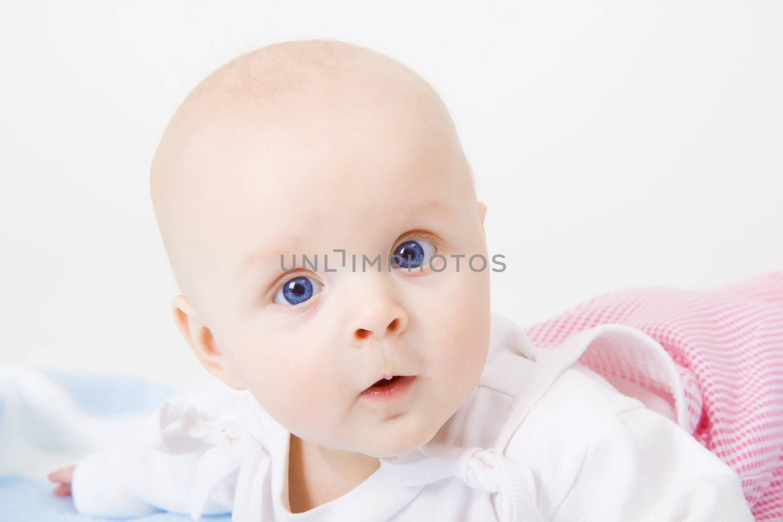 baby girl lying on a white background
