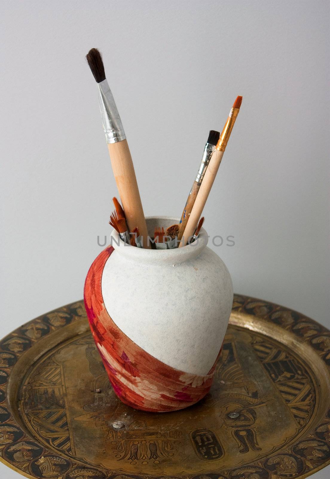 vessel with artistic brushes on stand