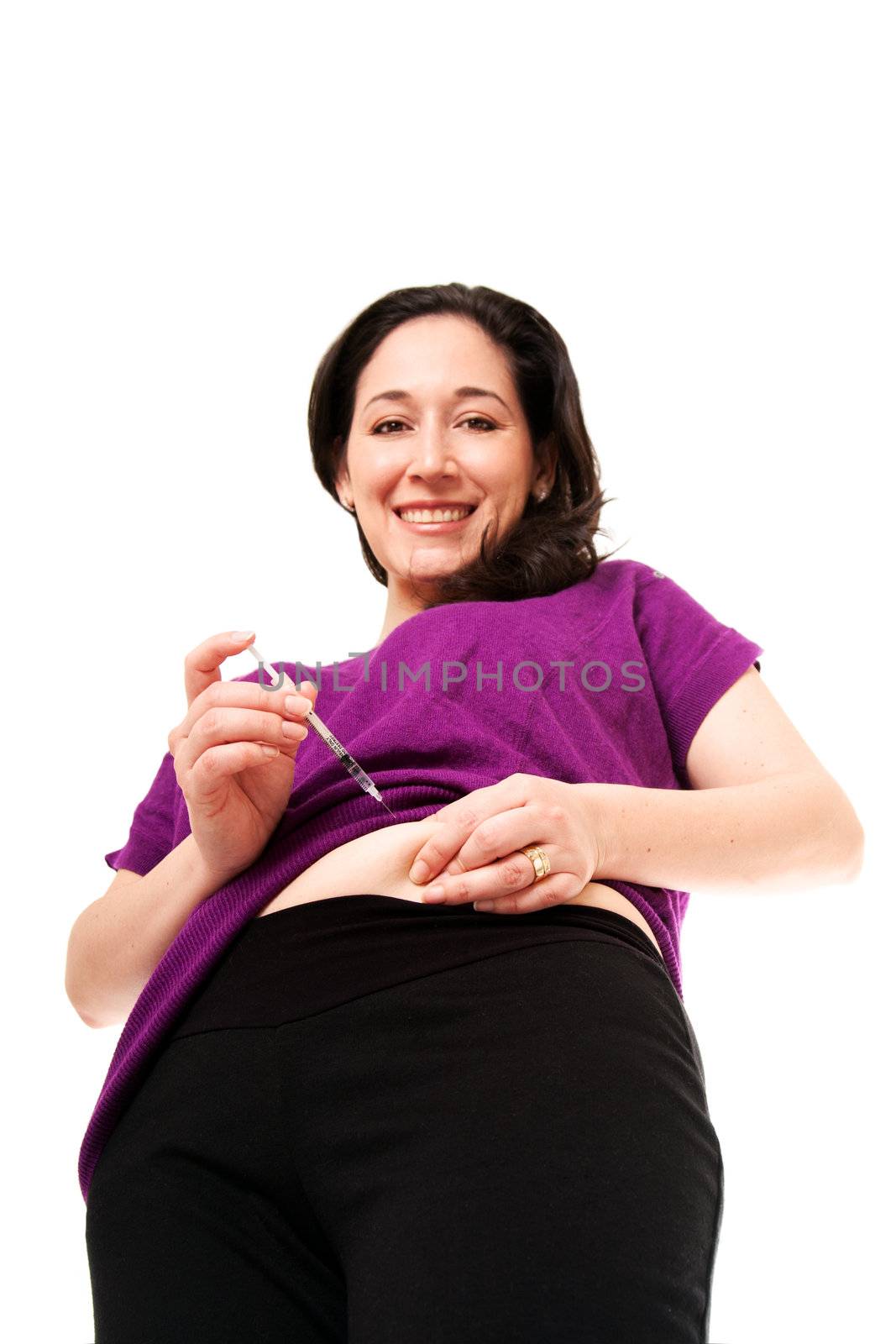 Attractive happy diabetic woman injecting insulin in her belly for health, isolated.