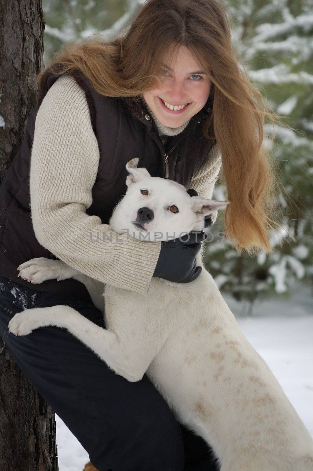 girl and a white dog in winter forest