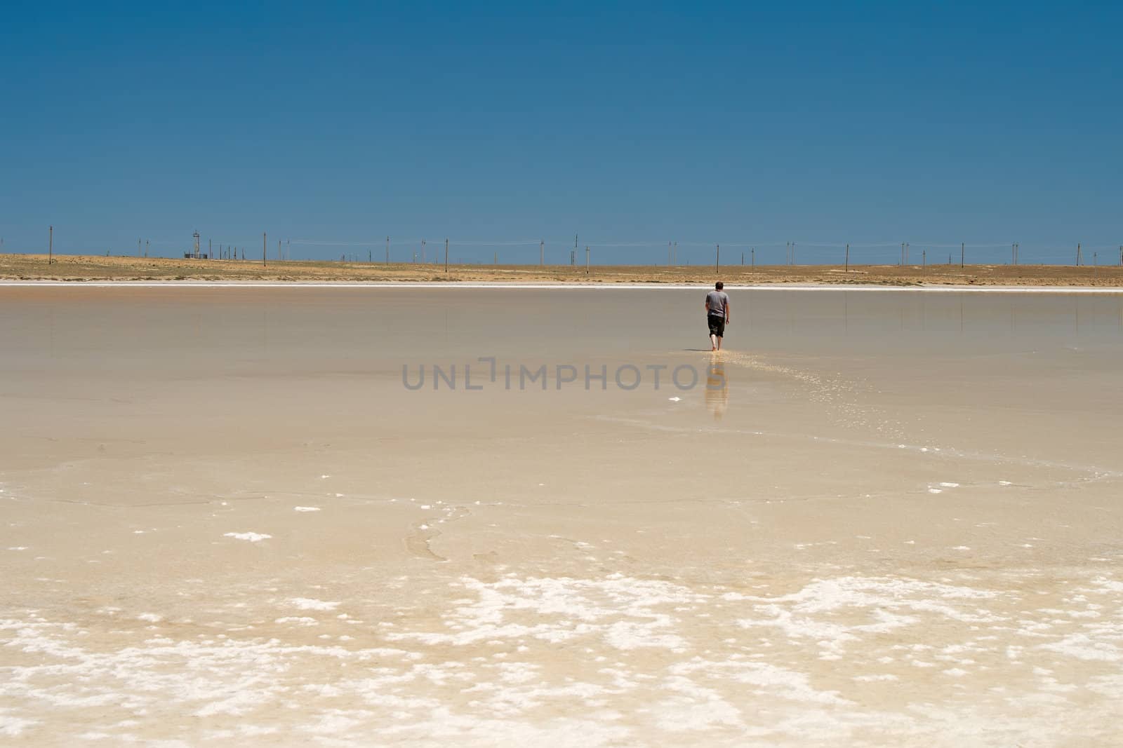 The guy walking barefoot on the salt lake.