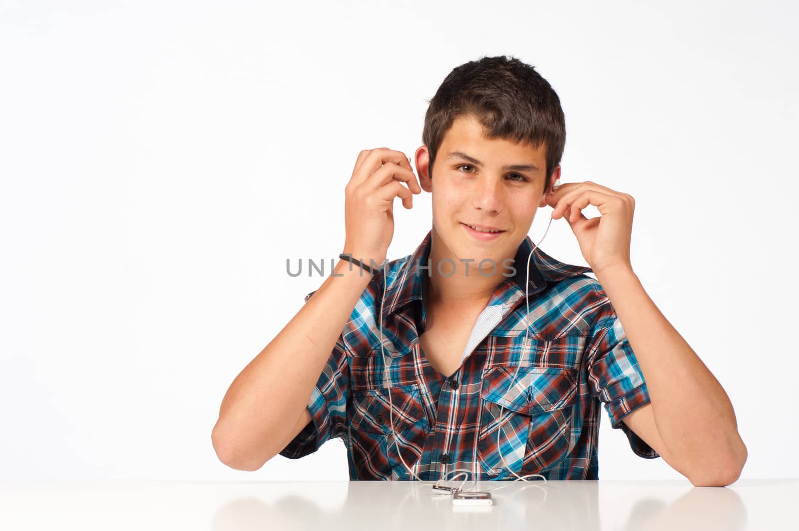 Teen enjoying his MP3 player, isolated on white