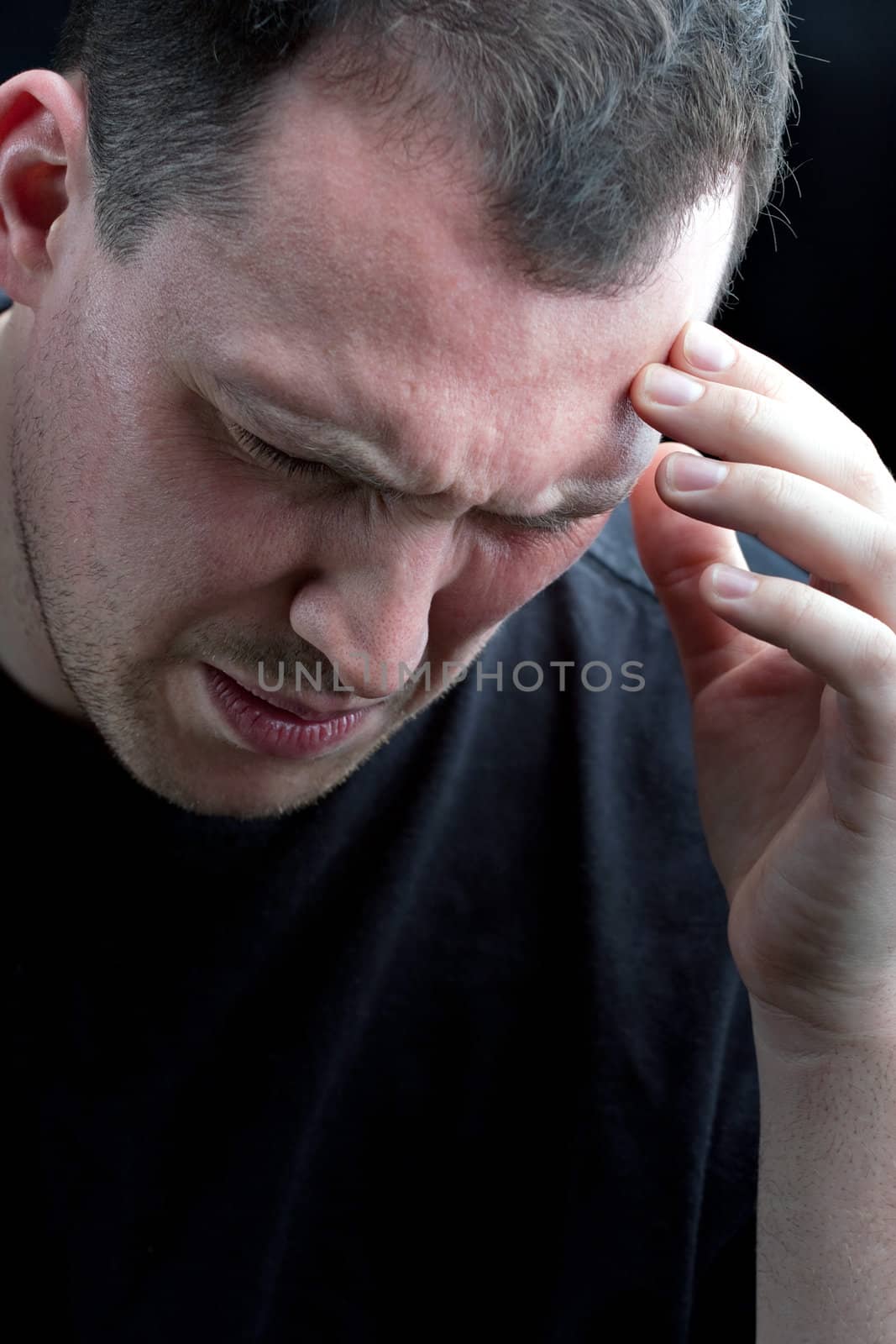 A man with an intense headache or migraine. He might also be experiencing stress during a time of economic crisis or other hardship.