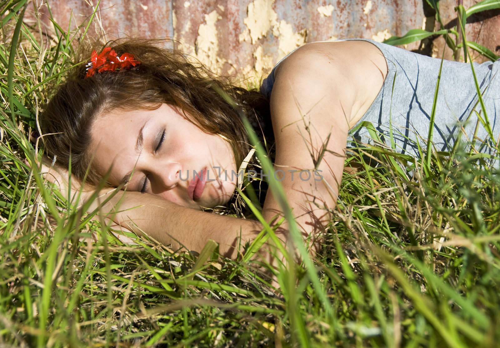 Beautiful teenage girl sleeping in a field by tish1