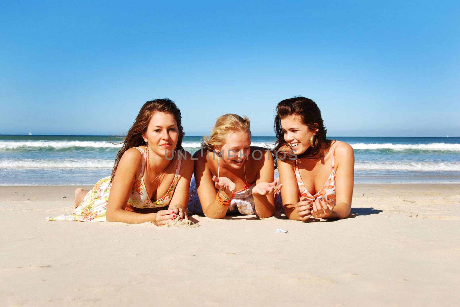 Three young woman having fun on the beach on a summer day by tish1