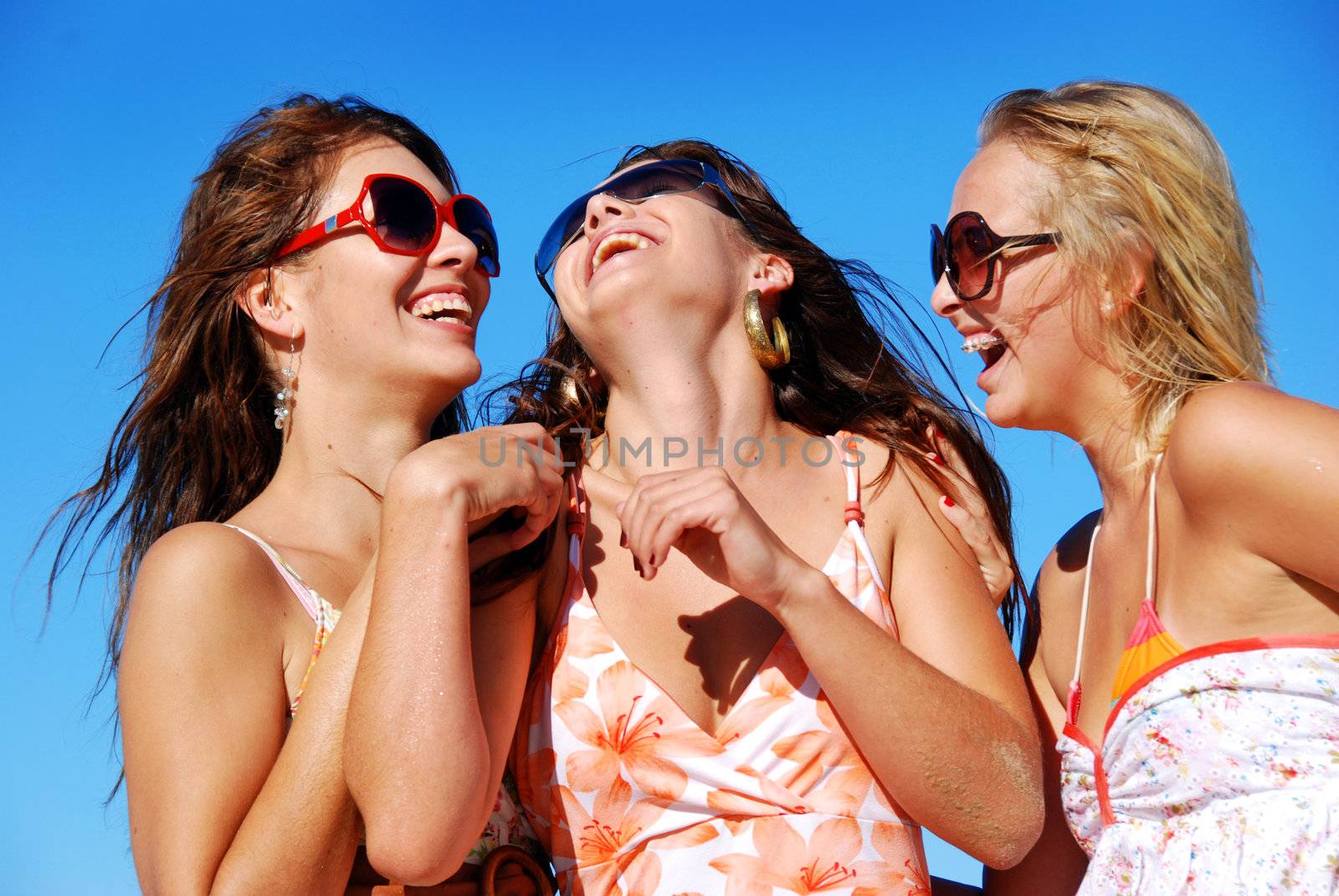 Three young woman having fun on the beach on a summer day by tish1