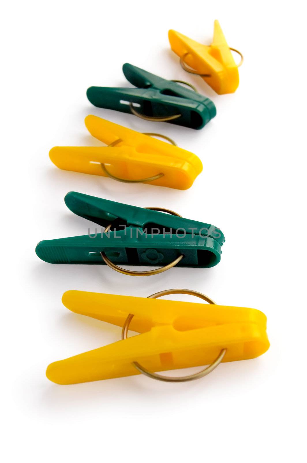 A number of yellow and green clothespins isolated on a white background