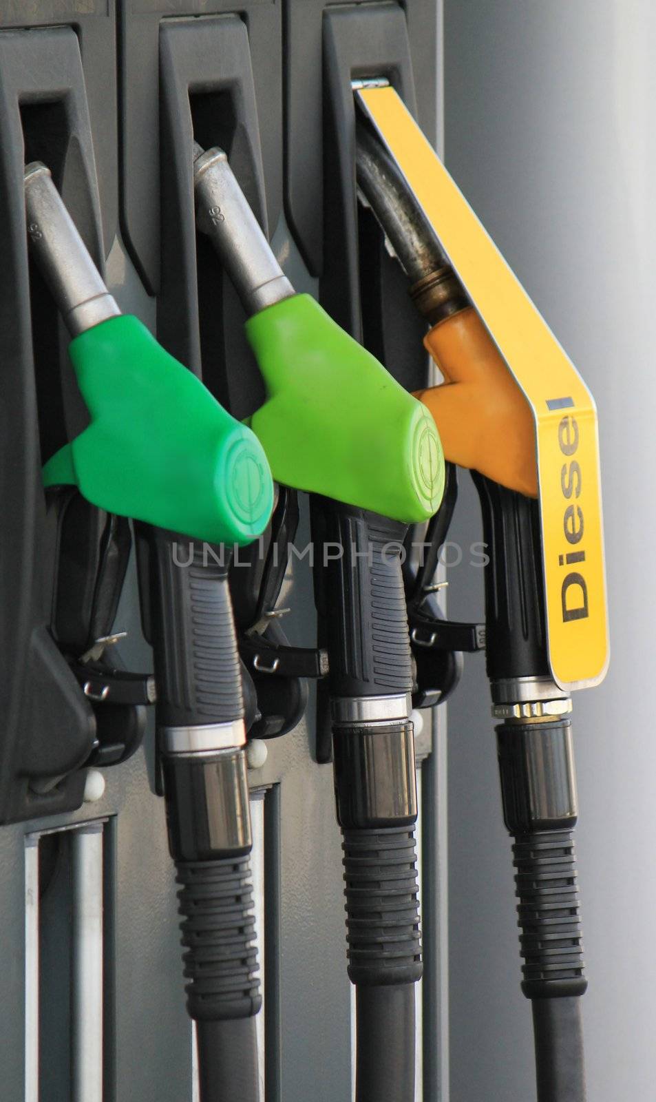 Close up of three gas and diesel pump nozzles on a petrol station