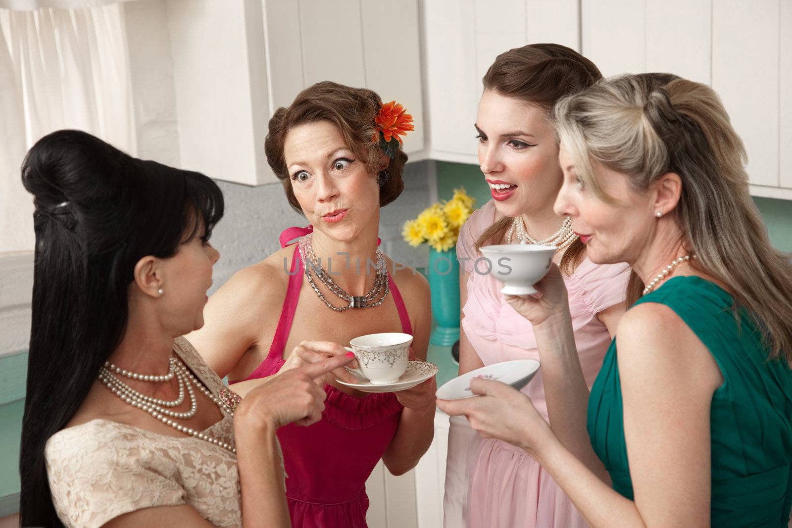 Four retro-styled women chit-chat over coffee in a kitchen
