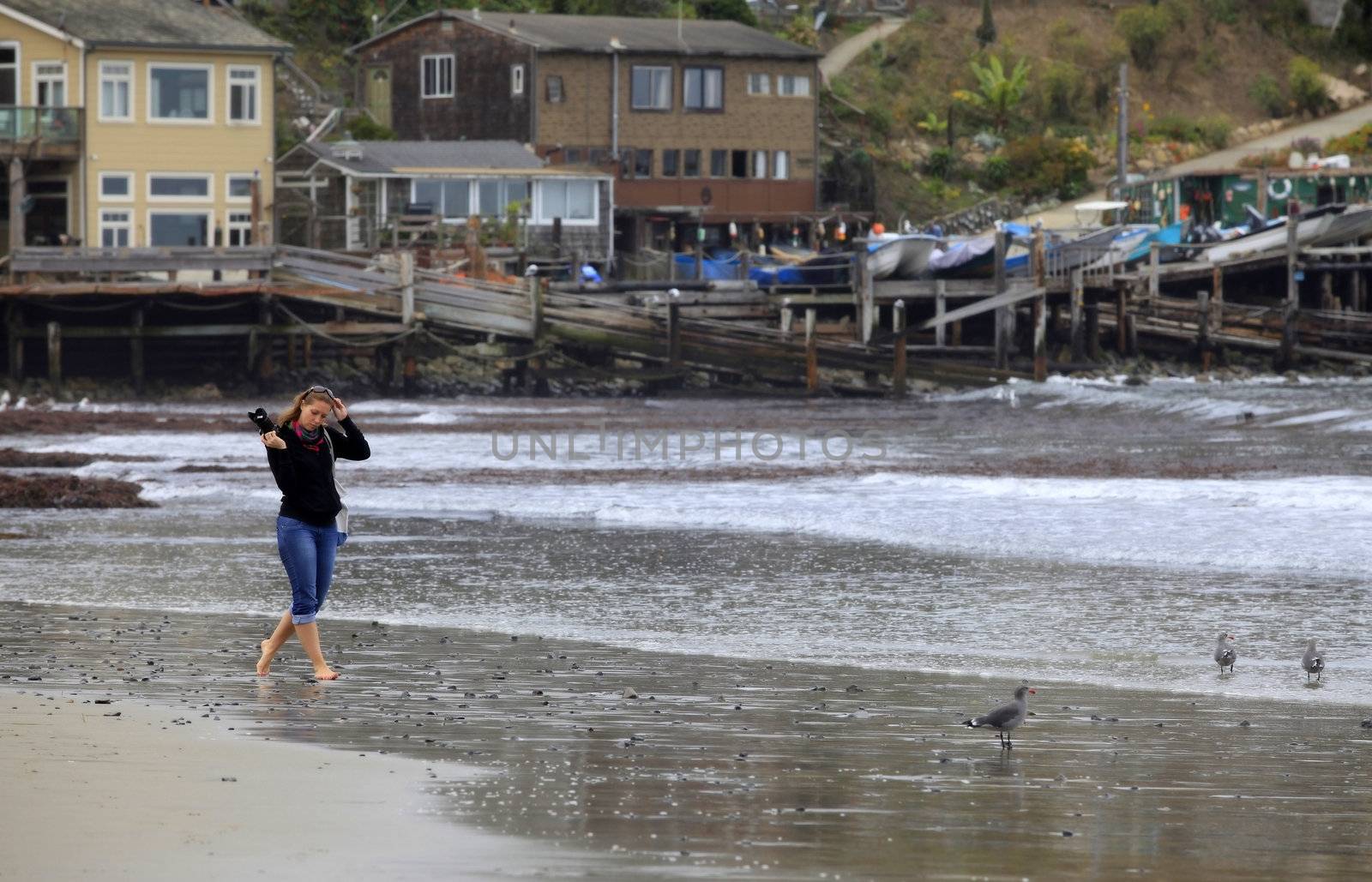 The girl with the camera on a coast of ocean. San Francisco