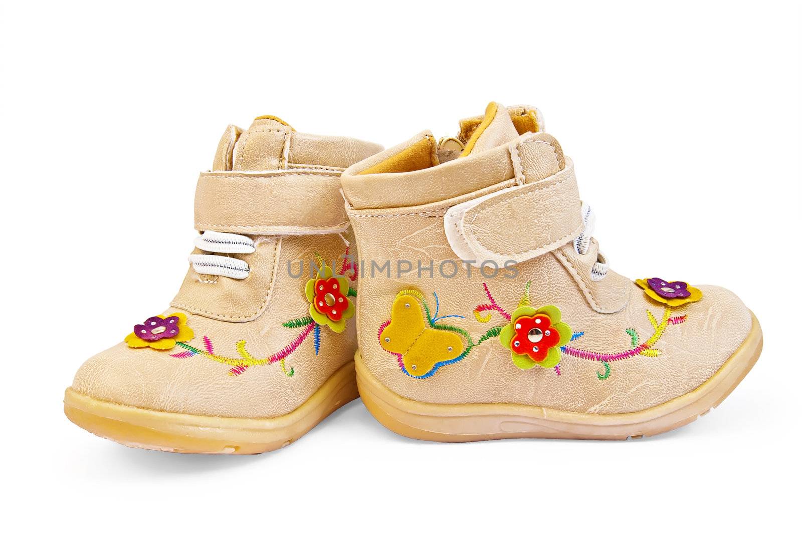 Beige baby shoes for girls with embroidery and applique isolated on a white background