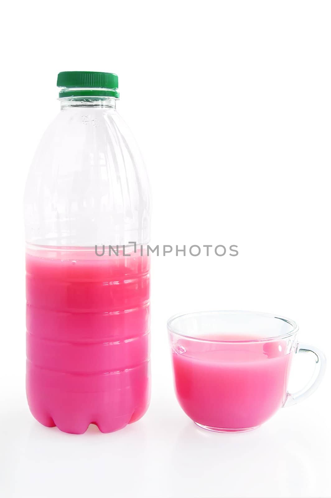 A plastic bottle and glass cup srozovym drink from whey and juice isolated on a white background