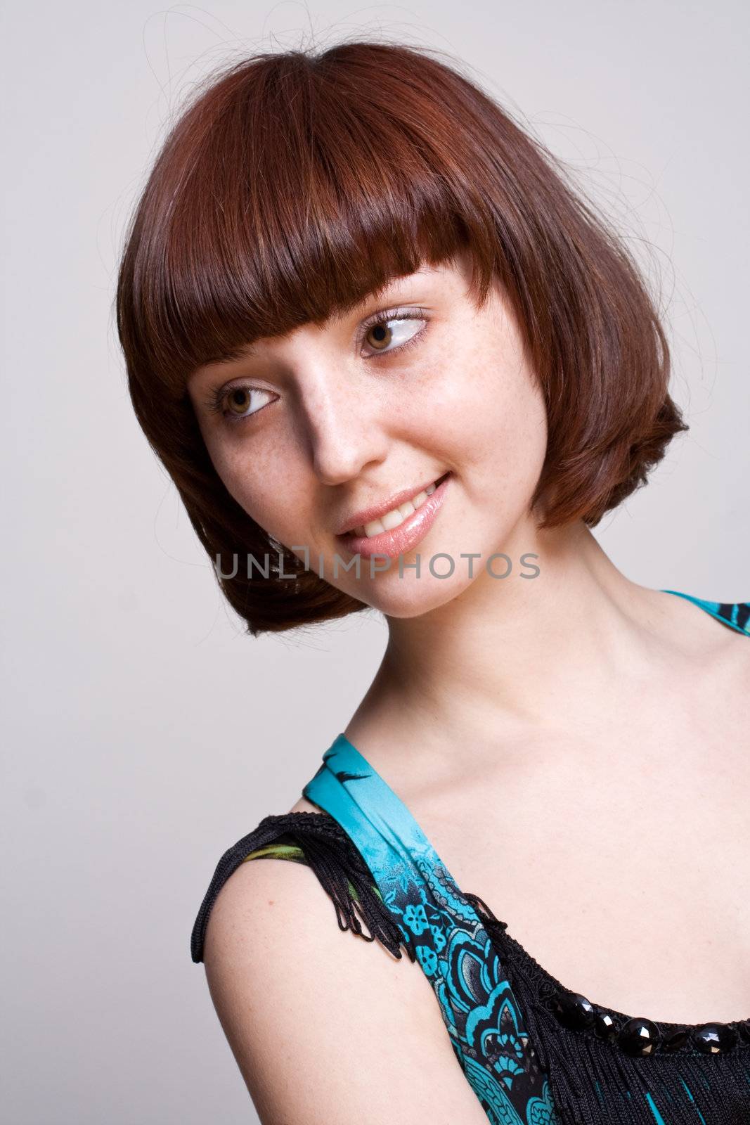 laughing girl in a dress on a gray background