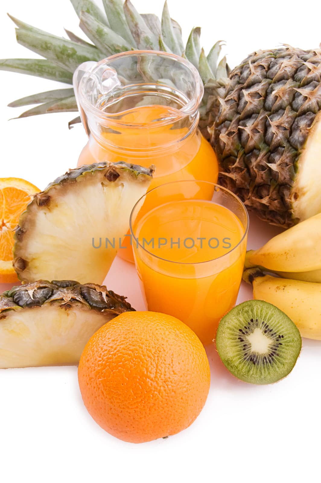 Jug and glass of multivitamin juice with pineapple and orange