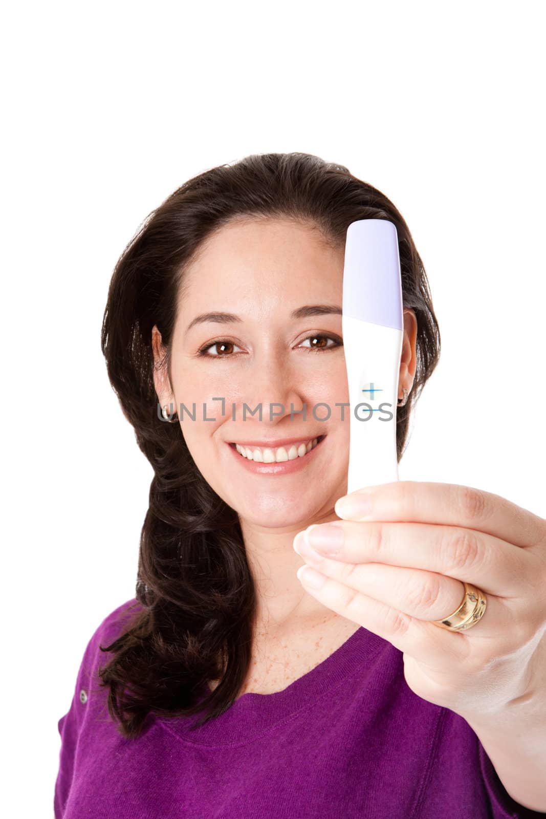 Attractive happy smiling woman finds out she is pregnant of a baby with a positive pregnancy test held in her hand, isolated.