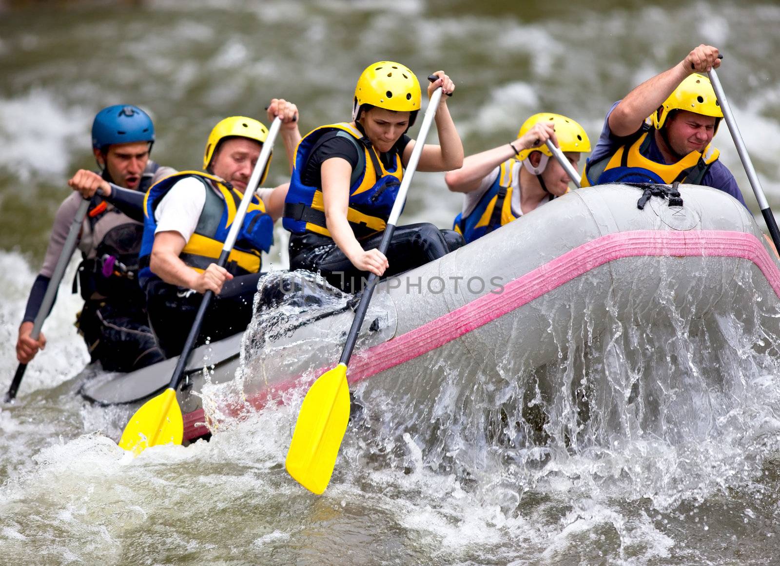 Group of people whitewater rafting on a river