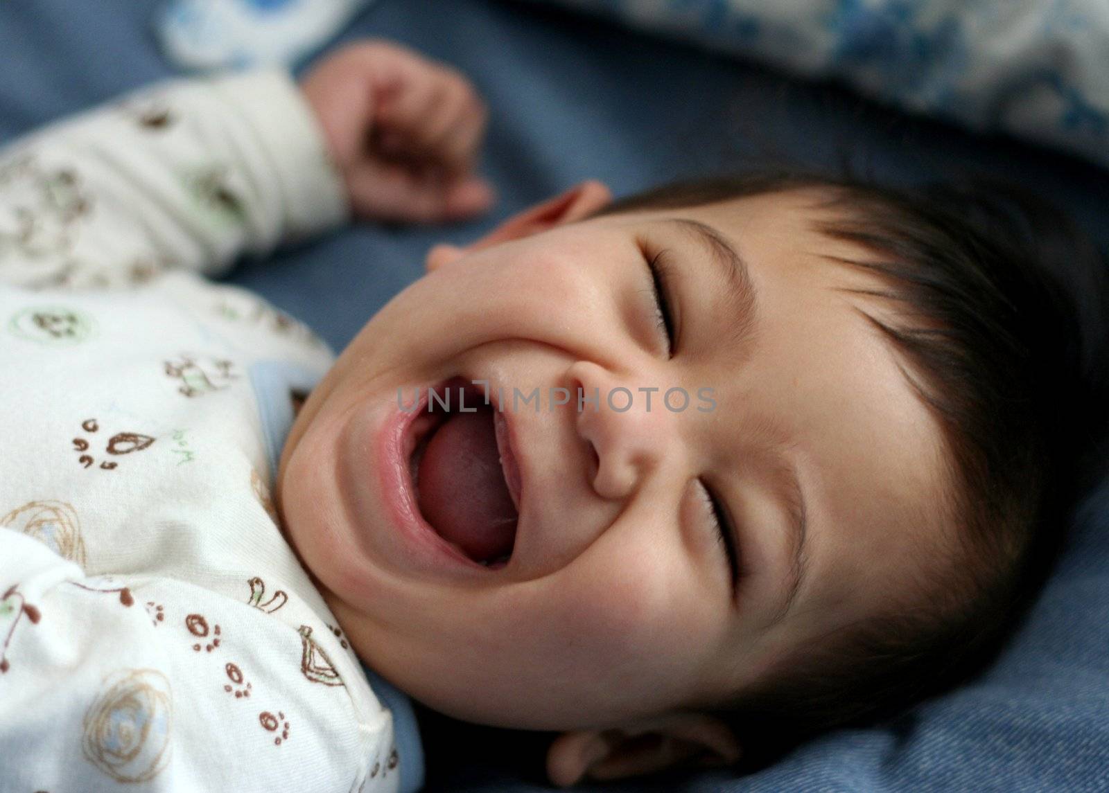 Happy six month old baby on bed by jarenwicklund