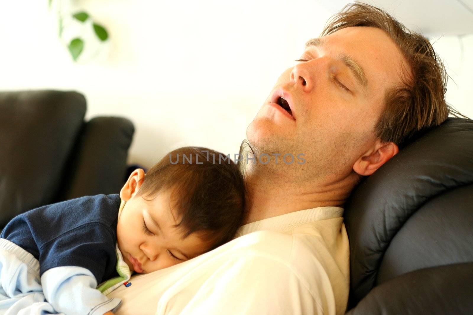 Baby asleep on his father's chest.