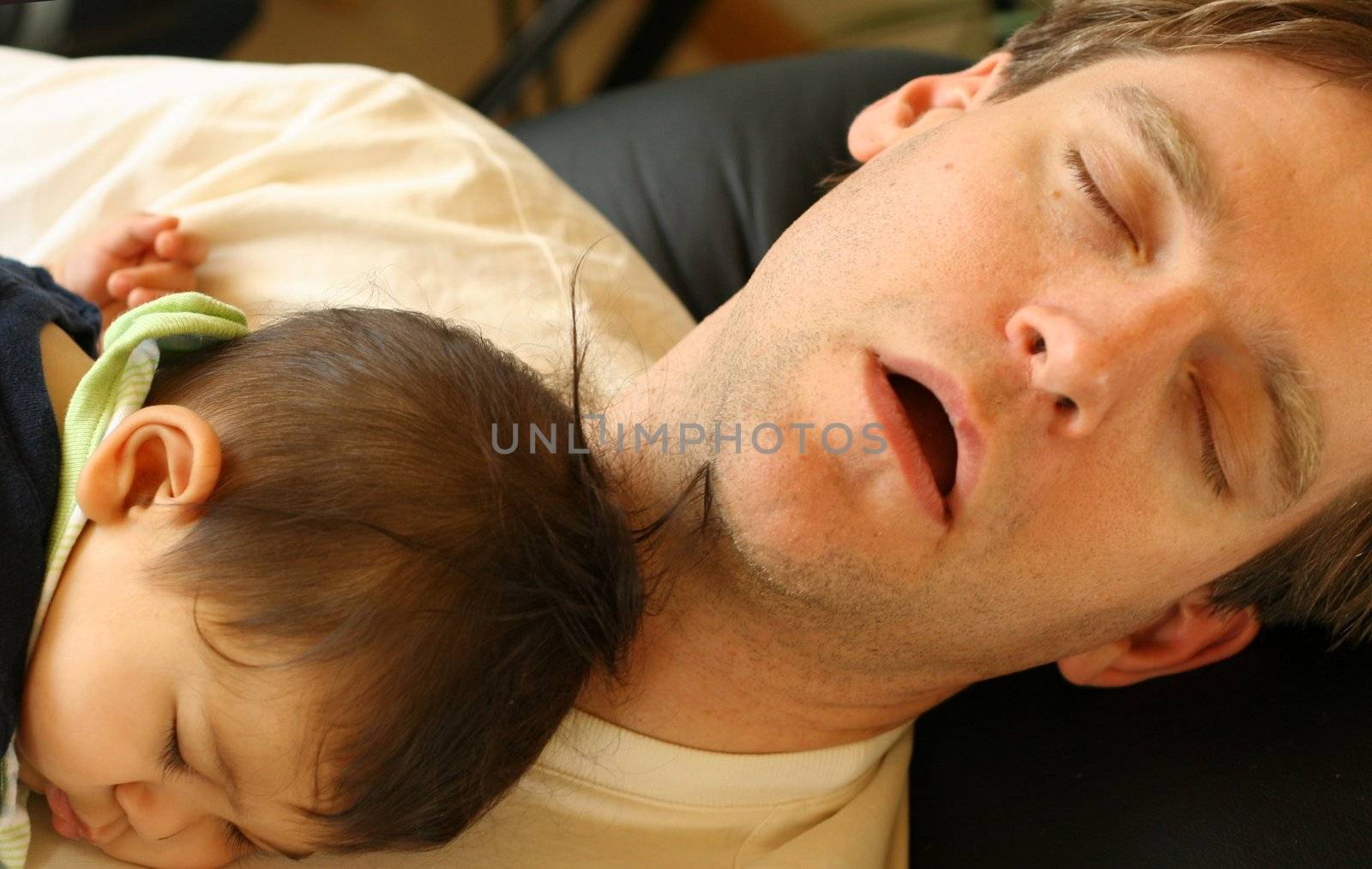Baby asleep on his father's chest.