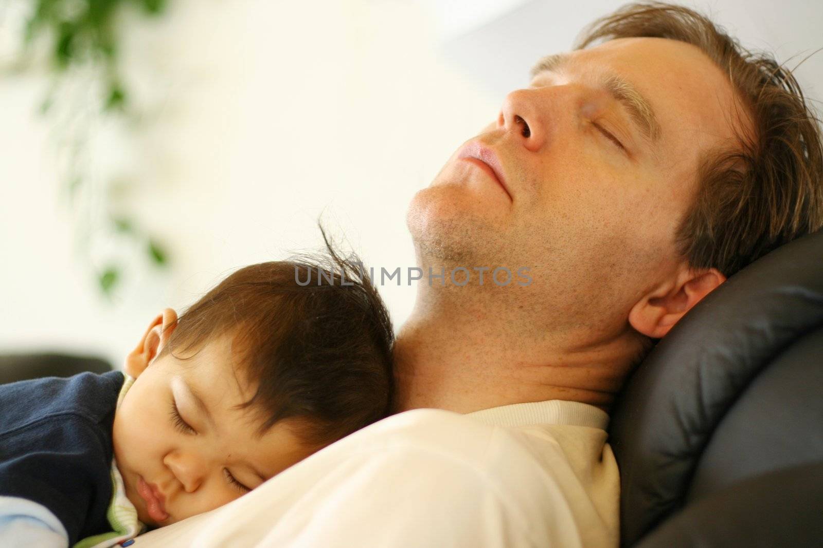 Baby asleep on his father's chest.